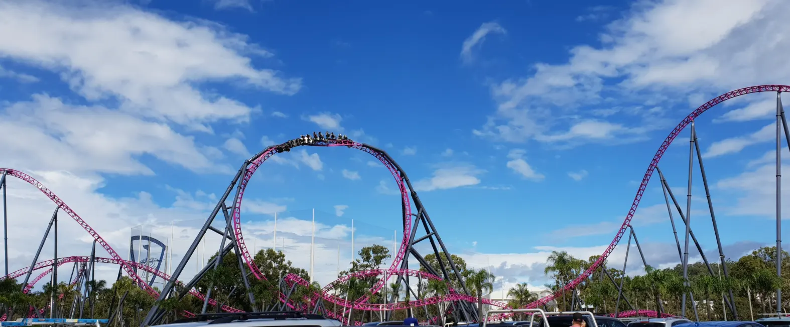 The pink DC Rivals HyperCoaster looping against a blue sky at Warner Bros. Movie World, Gold Coast